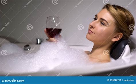 Pretty Female Holding Wine Glass Resting In Bath With Foam Bubbles Home Spa Stock Image