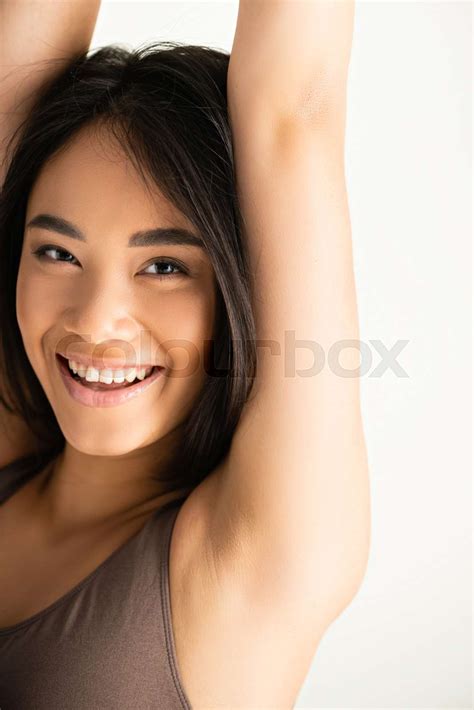 cheerful asian woman with hands above head laughing isolated on white stock image colourbox