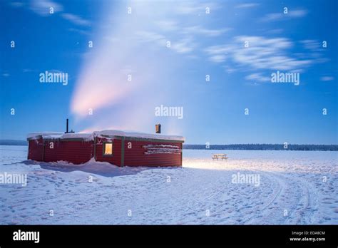 Winter Landscape With Cabin Hut Over Frozen Lake At Night In Kiruna