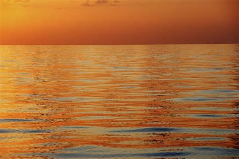 Calm Sea Surface With Orange Sunset Photograph By Axiom Photographic