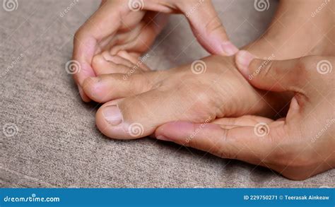 Closeup Of Female Holding Her Painful Feet And Massaging Her Bunion