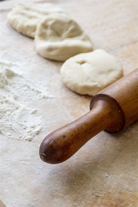 A Rolling Pin Front View Raw Dough And Flour Lie On A Wooden Table