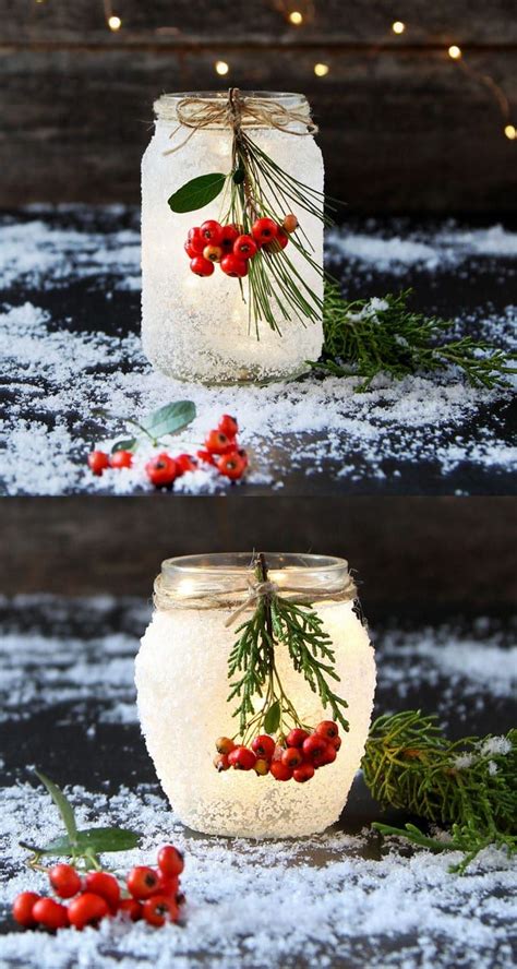 Two Mason Jars Decorated With Berries And Greenery Are Sitting In The