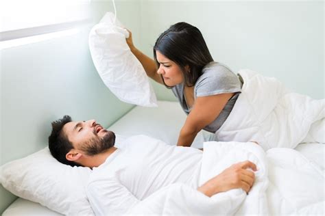 Premium Photo Attractive Hispanic Man Sleeping And Snoring While Her Angry Girlfriend Grabs A