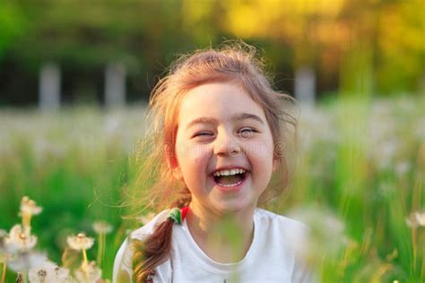 Beautiful Little Girl Laughing And Playing With Flowers In Sunny Spring