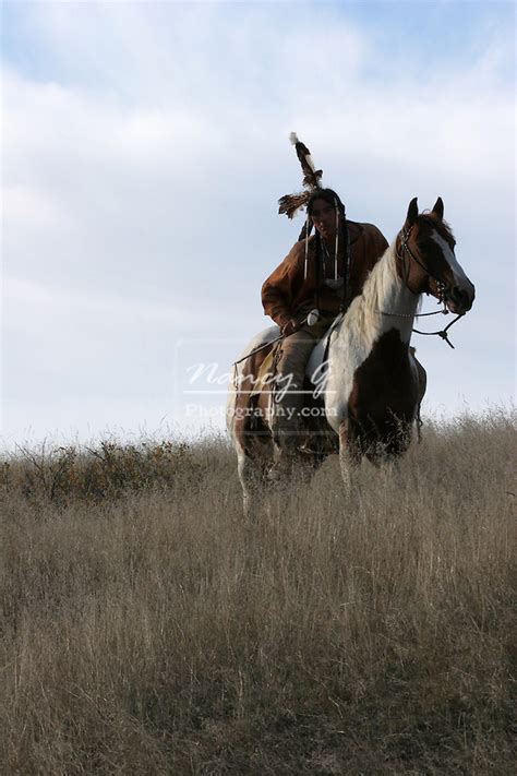 A Native American Indian Man Sitting Bareback On A Horse Leaning