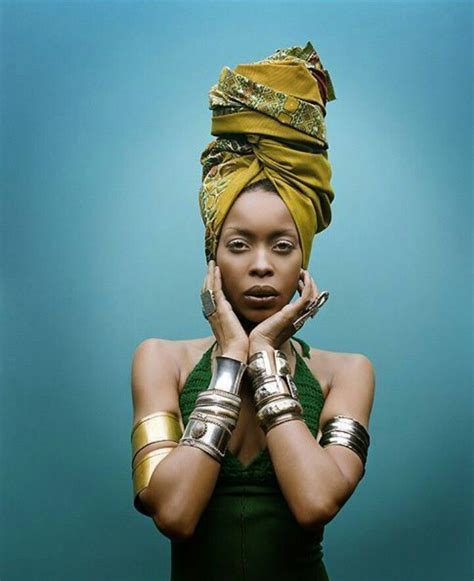 a woman in a green dress and gold head wrap holding her hands to her face