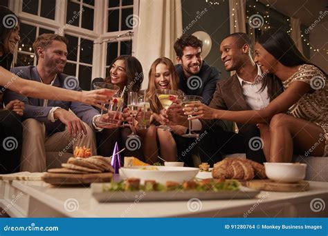 Friends Eating Snacks As They Celebrate At Party Together Stock Photo