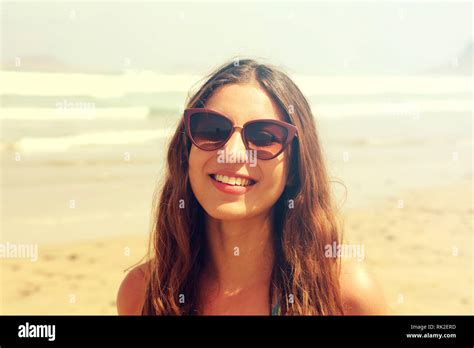 Portrait Of Beautiful Brunette Woman Smiling With Sunglasses On Beach At Sunny Day Image With