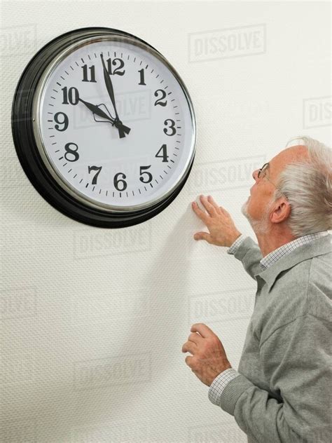 Senior Man Looking At A Large Clock Stock Photo Dissolve