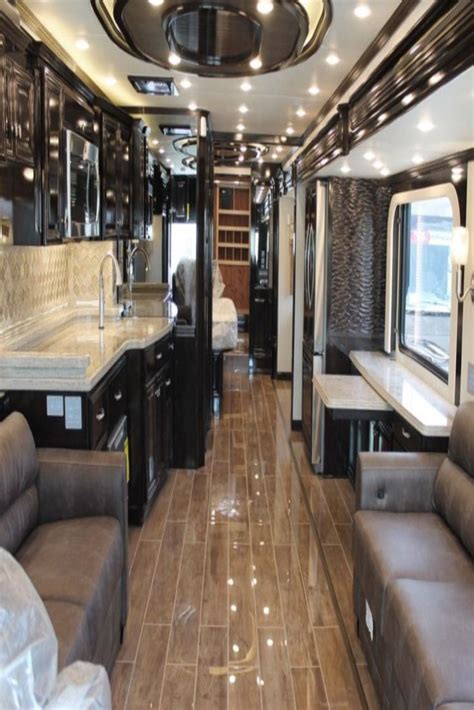 The Interior Of A Recreational Vehicle With Couches And Kitchen Area In
