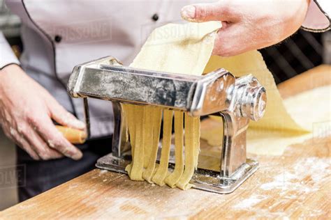 cropped image of chef making pasta with pasta maker - Stock Photo ...