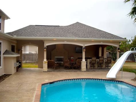 Guests enjoy shaded chaise lounges and umbrellas on the main pool deck. Recent project for a pool house with outdoor kitchen and ...