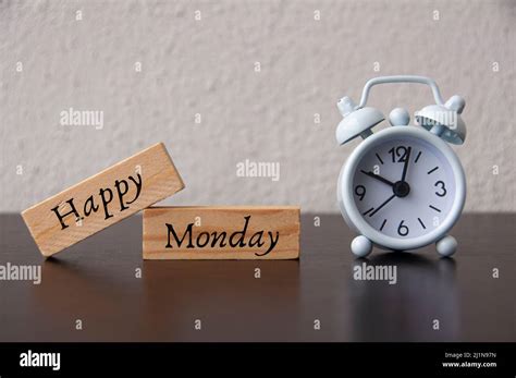 Happy Monday Text On Wooden Blocks With White Alarm Clock Background