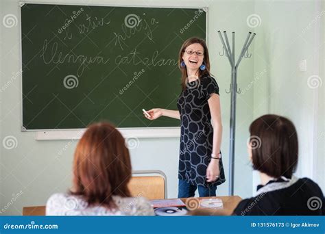 Spanish Teacher Young Attractive Girl At The Blackboard Explains The Learning Material To