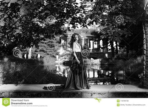 Pretty Woman In White Dress With Red Flying Skirt In Park Stock Photo
