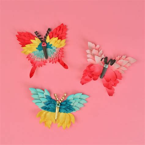 Three Colorful Butterfly Brooches On A Pink Background With Scissors In