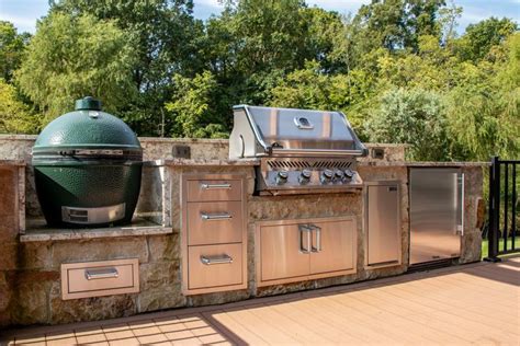 An Outdoor Kitchen With Grills And Cabinets On The Outside Decking Area