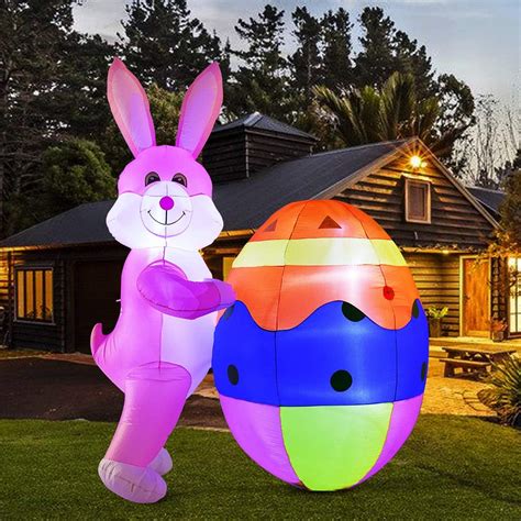 an inflatable easter egg and bunny standing next to each other on the lawn