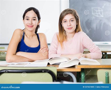 Young Girls Are Sitting At The Desk In The Classroom Stock Image