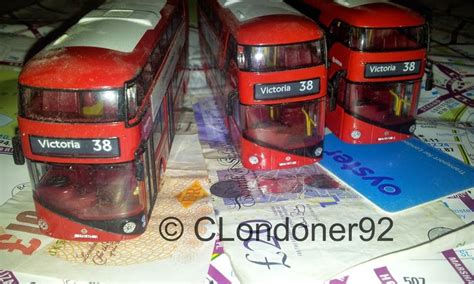 Three Red Double Decker Buses Sitting Next To Each Other On Top Of A