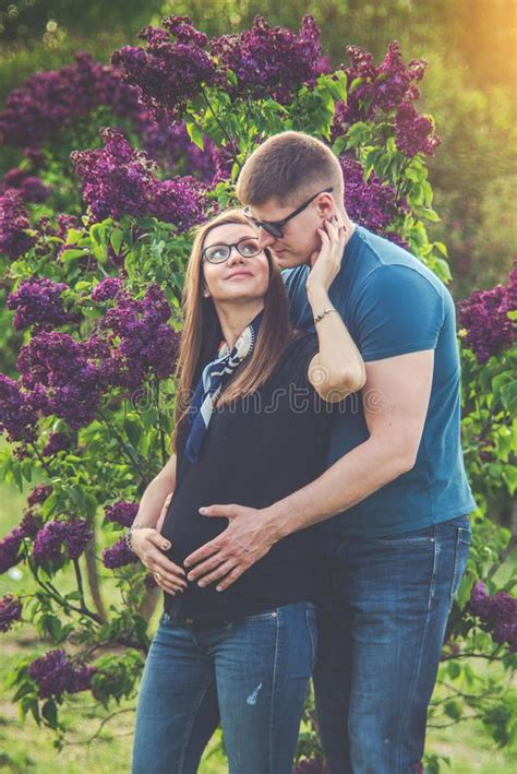 Couple Of Man And Pregnant Woman Are Sitting On A Bench Stock Image