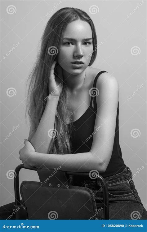 Beautiful Woman Sit On Chair And Touching Her Long Hair Stock Photo