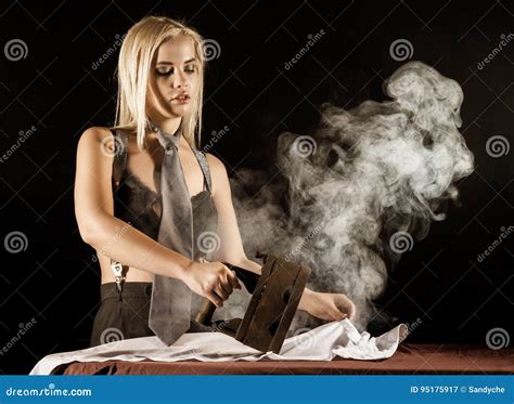 Blonde Woman In Men`s Pants And A Bra Ironing White Shirt With Old Iron Retro Style Stock