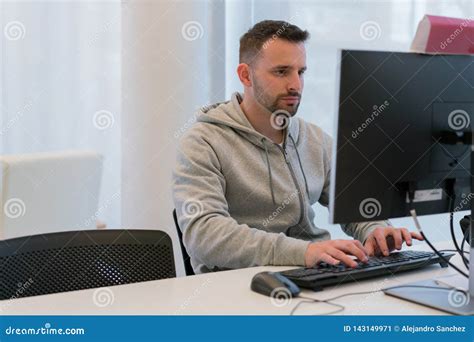 Young Calm And Concentrated Man Typing On The Computer Keyboard Looking