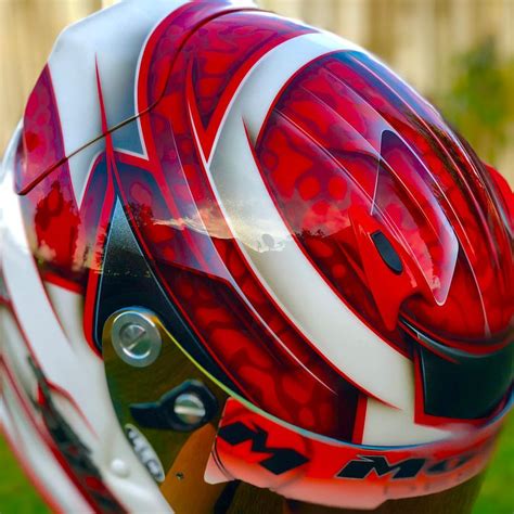 The Helmet Is Red And White With Designs On It