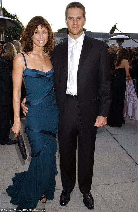 A Man And Woman Standing Next To Each Other In Formal Wear At An Outdoor Event
