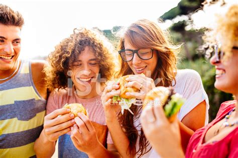 Friends Eating Burgers Stock Photo Royalty Free Freeimages