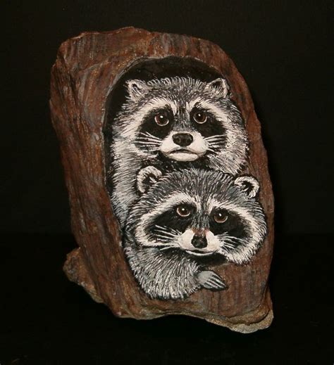 Three Raccoons Carved Into A Rock On A Black Surface With The Image In