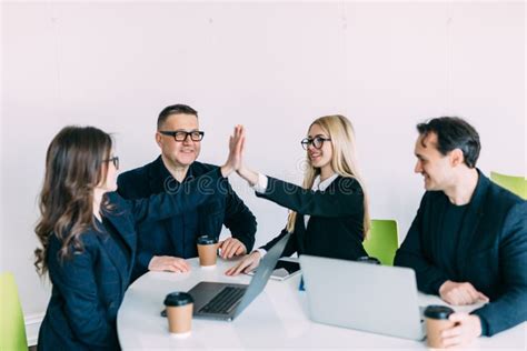 Business People Giving Each Other High Five In Office Business Team