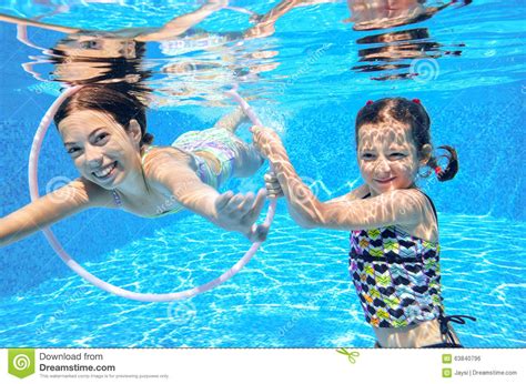 Children Swim In Pool Underwater Happy Active Girls Have Fun Under