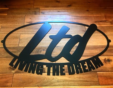 The Logo For Living The Dream Is Shown On A Wooden Floor In Front Of A