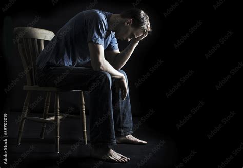 Depressed Or Sad Man Sitting On Chair In The Dark Stock Photo Adobe Stock