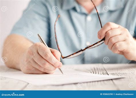 Closeup Of Businessman Hands Writing Something On Piece Of Paper And