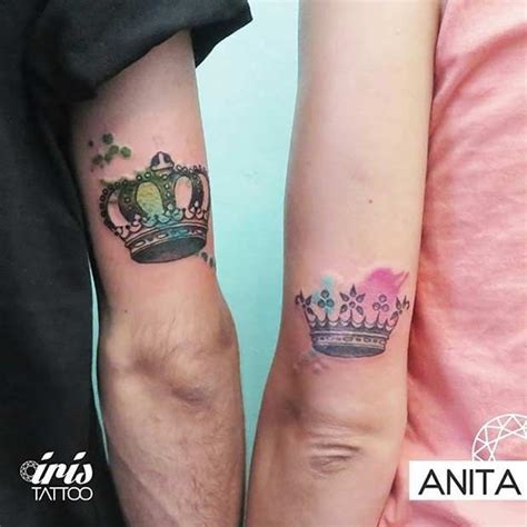 two people wearing matching tattoos with crowns on their arm and one holding the other s hand