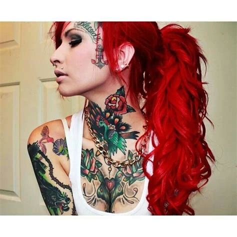 A Woman With Red Hair Has Tattoos On Her Face And Neck While Wearing A White Tank Top