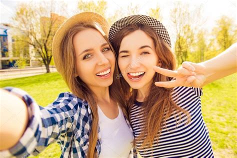 Two Pretty Girls Making Selfie Gesturing With Two Fingers And S Stock