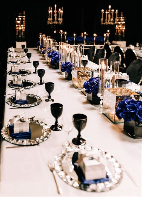 A Long Table Is Set Up With Blue Flowers And Candles For An Elegant