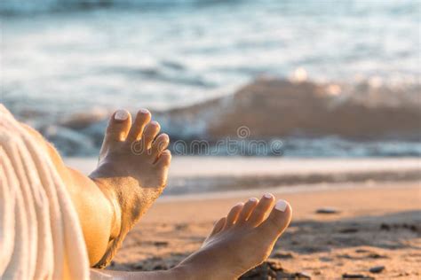 Female Feet On The Beach Tanned Legs Of A Girl Close Up Girl Resting On
