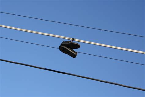 Silhouette of sneakers on power lines. Shoes Hanging from Power Lines Picture | Free Photograph ...