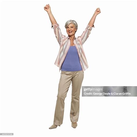 Front View Portrait Of Mature Woman Standing With Arms Raised High Res