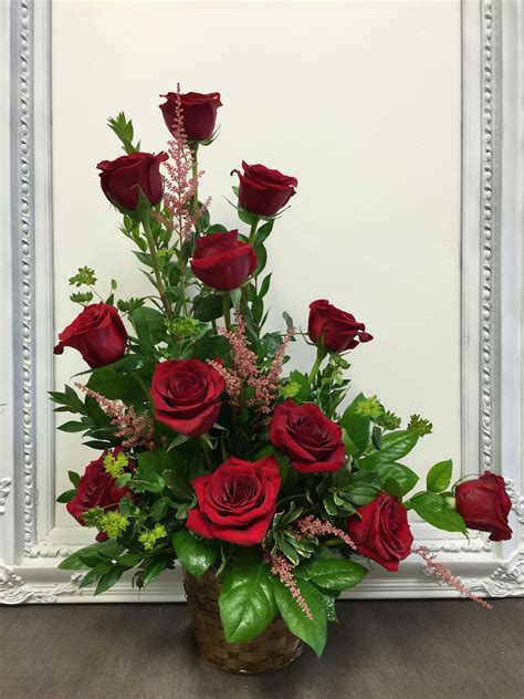 a dozen red roses beautifully arranged one sided in a basket notyouraveragedozenroses