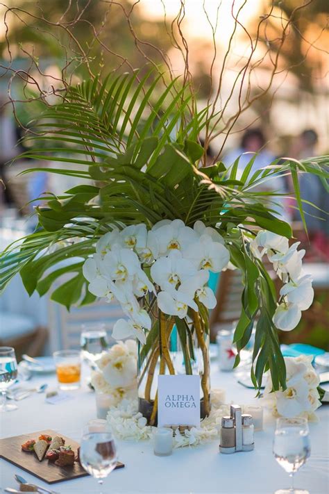 Tropical Wedding Centerpiece With Palm Leaves Monstera Leaves White Orchids And Some Bran