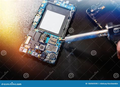 Technician Repairing The Smartphone S Motherboard By Soldering In The