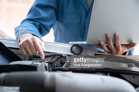 Closeup Shot Of Auto Mechanic Working On Laptop At Automobile With