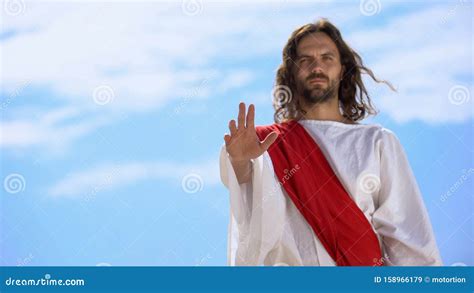 Jesus In Robe Stretching Opened Palm On Camera Blessing And Healing